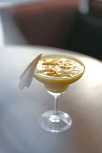 Close up shoot of fresh mango smoothie on martini glass served on the table