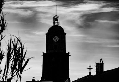 Low angle view of clock tower amidst buildings against sky