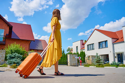 Low angle view of man standing on street against sky
