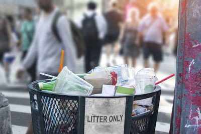 Close-up of garbage bin on street in city