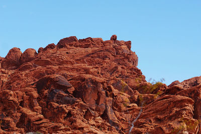 Low angle view of rock formations against clear blue sky