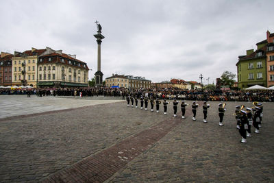 Panoramic shot of people in city against sky