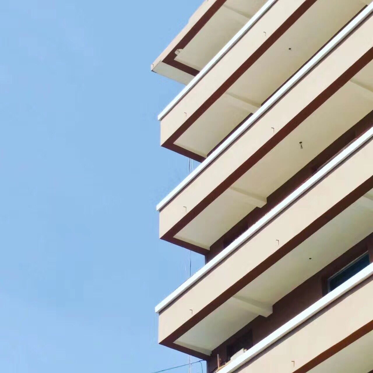 LOW ANGLE VIEW OF MODERN BUILDING AGAINST CLEAR BLUE SKY