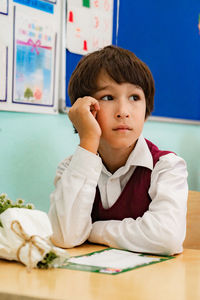 Boy looking away while sitting at classroom