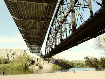 Low angle view of bridge over river against sky