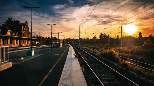 Railroad tracks against sky during sunset