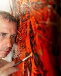 Portrait of young man holding red light
