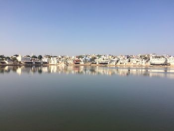 Scenic view of lake by houses against clear sky