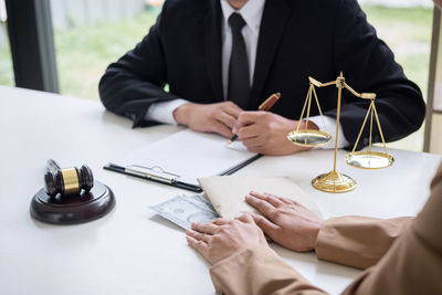 Midsection of lawyer with man at office