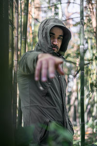 Portrait of a moroccan man pointing towards the camera with his right hand.