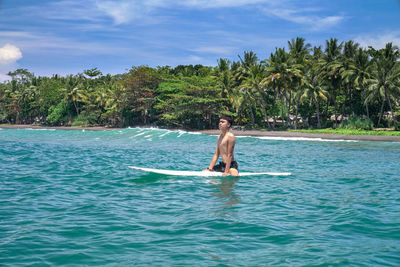 Man in boat on sea against sky