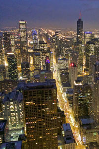 Illuminated cityscape against sky at night