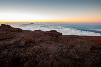 Rock formations on landscape against sky during sunset