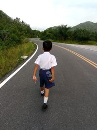 Rear view of man on road against sky