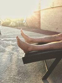 Low section of man relaxing against sky