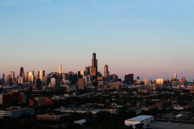 Modern buildings in city against sky during sunset