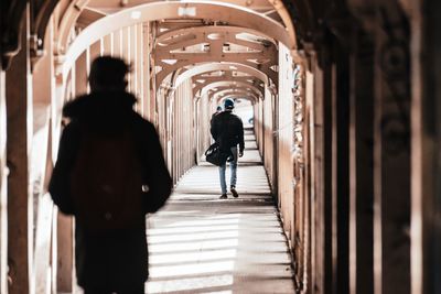 Rear view of people walking in corridor