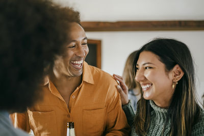 Happy man and woman in kitchen during party