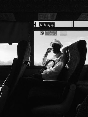 REAR VIEW OF MAN SITTING IN CAR