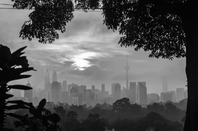 Silhouette trees and buildings against sky