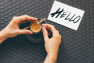 High angle view of hand holding coffee on table