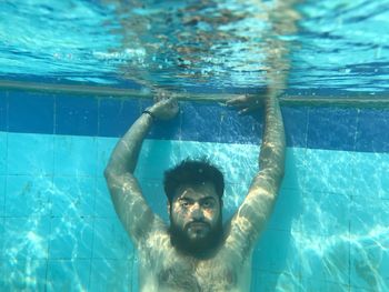 Portrait of young man swimming in pool