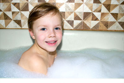 Happy little baby boy face swimming in the bathroom