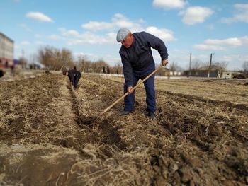 Rear view of men working on field