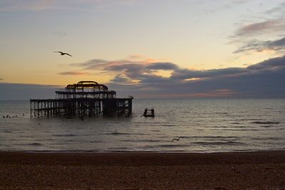 Abandoned pier on sea against clear sky