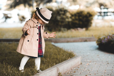 Full length of girl wearing hat standing at park