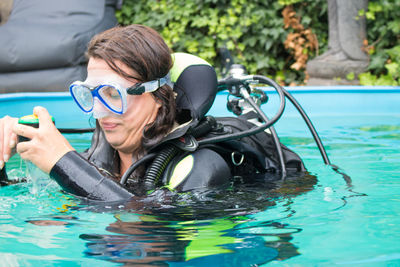 Woman wearing swimming goggles in swimming pool