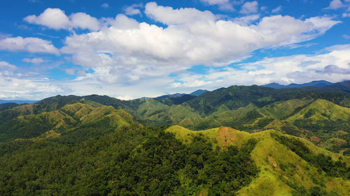 Green hills and mountains with tropical vegetation and blue sky with clouds