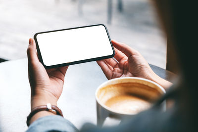 Cropped image of hand holding coffee cup