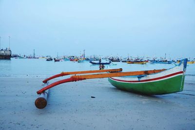 Boat moored at harbor against clear sky