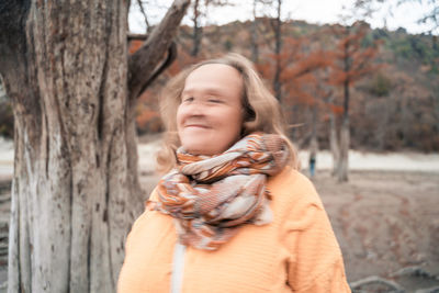 Portrait of smiling girl against tree trunk