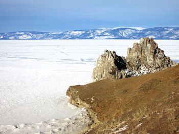 Scenic view of snowcapped mountain by sea against sky