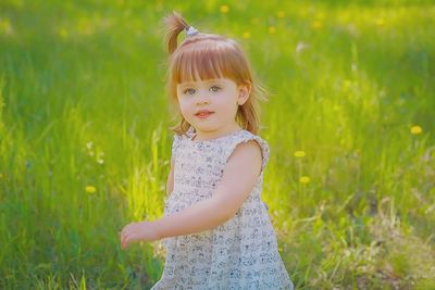 Portrait of cute girl standing on field