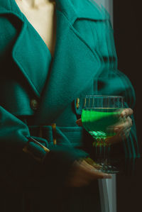 Close-up of man holding glass bottle on table