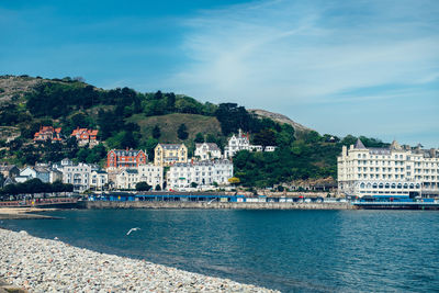 View of townscape by sea against sky