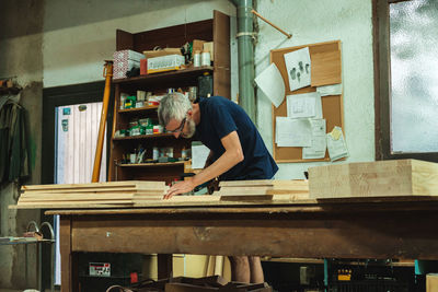 Craftsman working on wooden planks in workshop