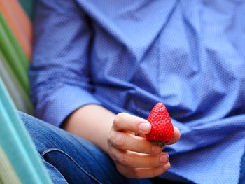 Close-up of hand holding strawberry