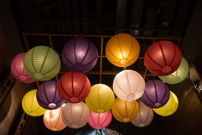 Low angle view of illuminated multi colored lanterns hanging on ceiling