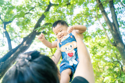 Father and son on tree against plants