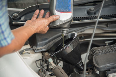 Man pouring oil into car