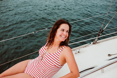 Portrait of smiling young woman against sea