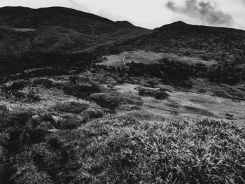 Scenic view of land and mountains against sky