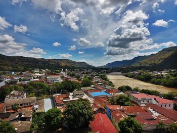 View of cityscape against cloudy sky