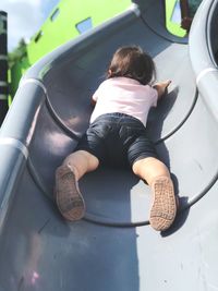 Low angle view of baby girl on slide at playground