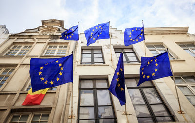 Low angle view of flags against buildings in city