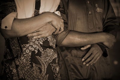 Midsection of couple holding hands